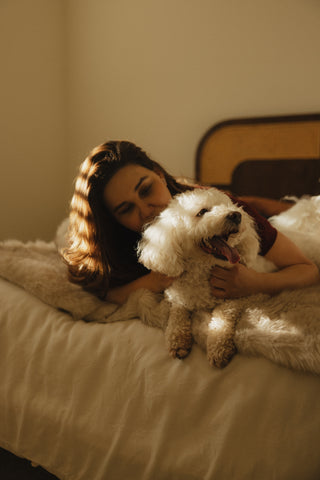 Woman lying beside her dog during quiet shared ritual
