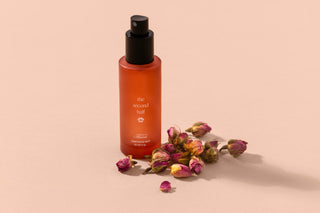 The Second Half pet mist bottle beside rose buds

